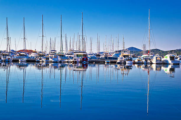 istock Sailboats and yachts in harbor reflections view 472802148