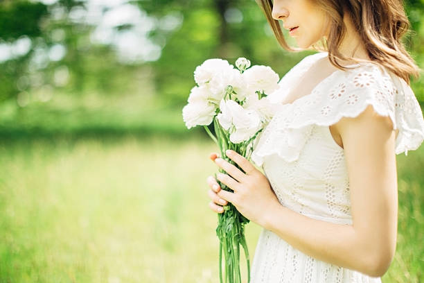 hermosa mujer sosteniendo un ramo de flores - cut flowers women field single flower fotografías e imágenes de stock