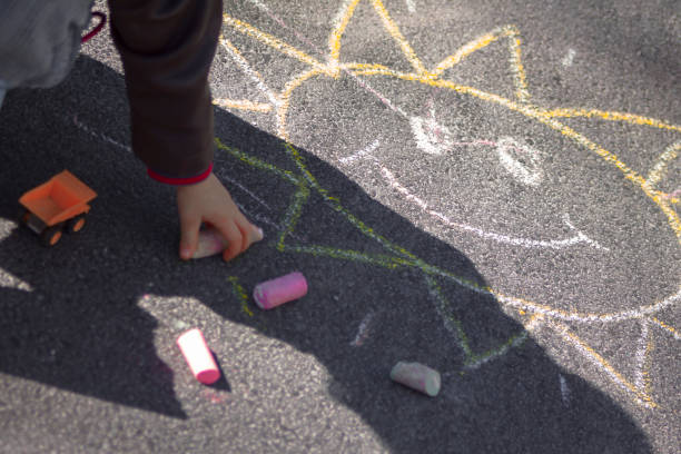 istock Child playing with sidewalk chalk and sunshine smiley 472807120