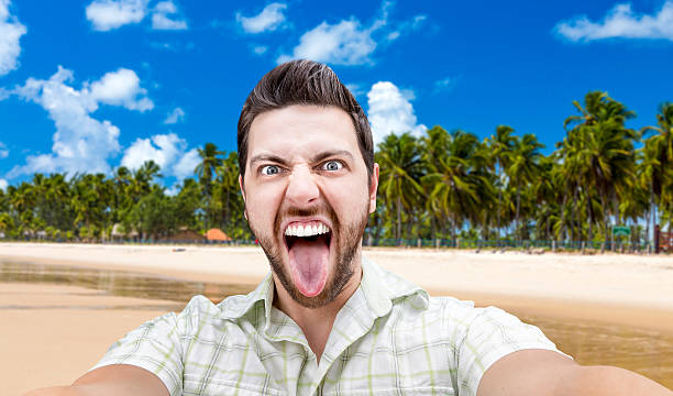 istock Happy young man taking a selfie photo on the beach 472809282