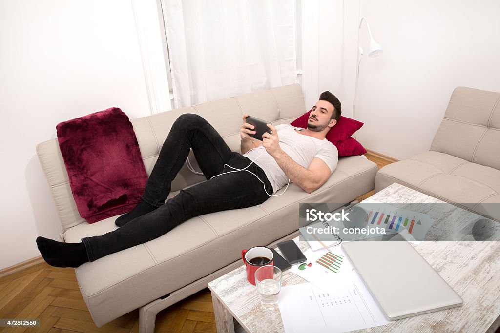 Relaxing after work Relaxing after working long hours at home 2015 Stock Photo