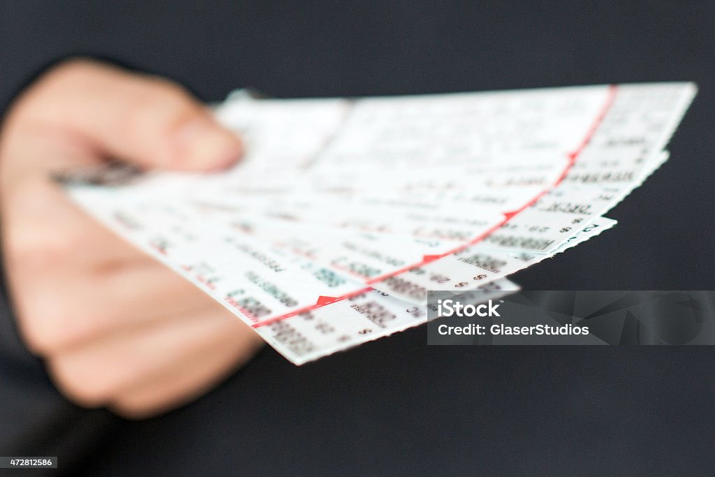 Tickets in hand Tickets to a show / event in a hand with a black background. Ticket Stock Photo