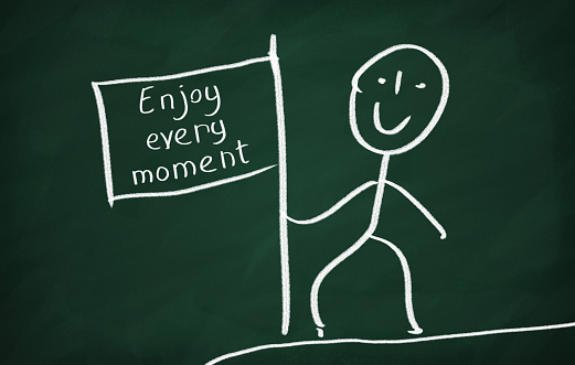 On the blackboard draw character and write Enjoy every moment