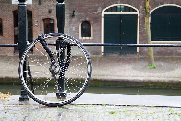 istock Bicycle wheel chained to the railings by a canal 472821820