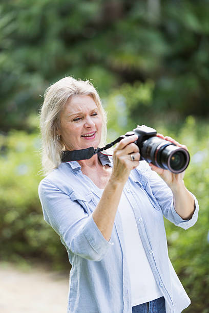 istock Senior woman taking photographs with camera 472821958