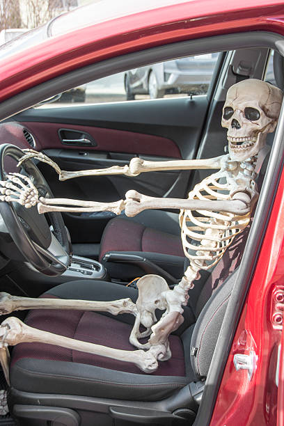 istock Skeleton driving a car as seen through side open door 472822340