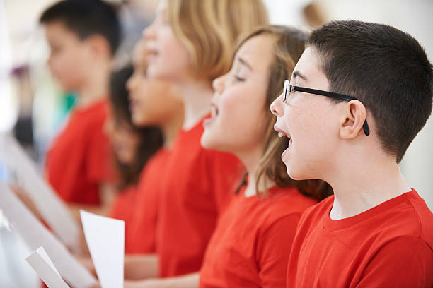 istock Group of school pupils in red clothes singing in choir 472822944