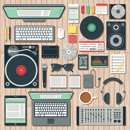 An overhead view of items you might find on the desk of a DJ (disk jockey), including: Laptop, tablet, smart phone, computer, turntable, headphones, splitter, speaker, CDs, records, microphone, hard drive, equalizer software, VIP pass, concert ticket, USB Flash drives, mixer, and so on. No gradients or transparencies used. File is organized into layers and each icon is properly grouped for easy editing.
