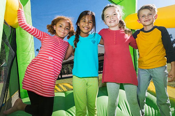 istock Four multi-ethnic children playing on bouncy castle 472823188