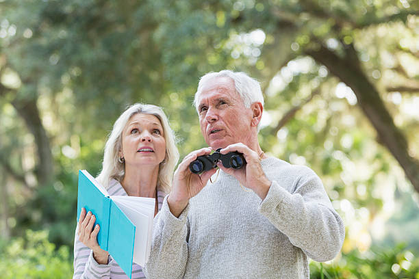 istock Senior couple in the woods birdwatching 472823194