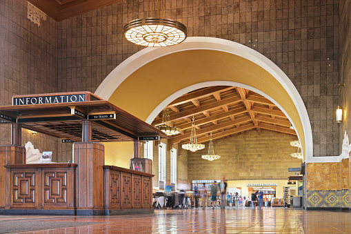 Passengers in the waiting room of Union station - the main transportation hub in Los Angeles. Designed by Parkinson & Parkinson (1939) who were responsible for City Hall and other local landmark, It combines Dutch Colonial, Mission Revival, and Streamline Moderne styles. It is in the national register of historic places (1980).