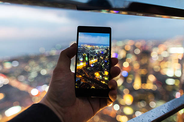 Making a photo with the telephone Making a photo with the phone at the fantastic view of Dubai, The shot is made from the top of Skyscraper. dubai photos stock pictures, royalty-free photos & images