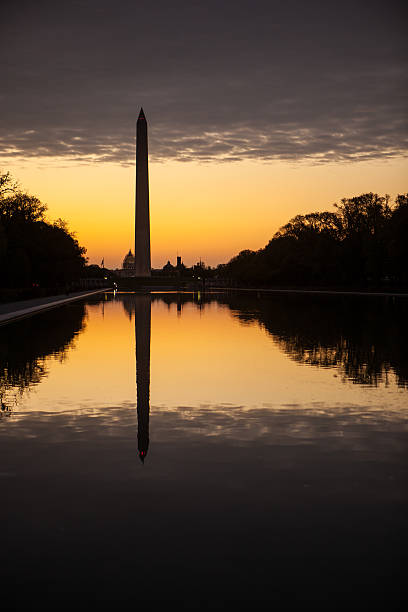 istock Washington Monument silhouetted at sunrise with reflection. 472825650