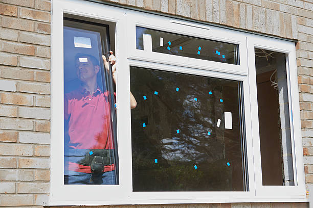 Construction Worker Installing New Windows In House stock photo