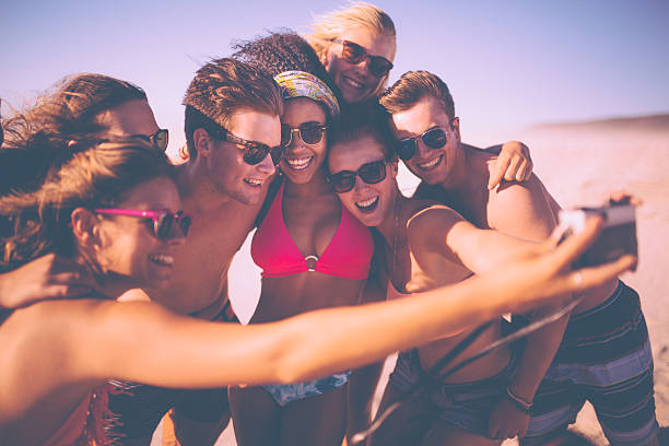 istock Group of friends taking a group selfie on a beach 472830424