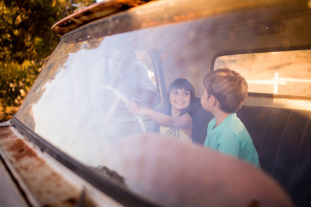 istock Siblings pretending to drive an old vehicle 472830510