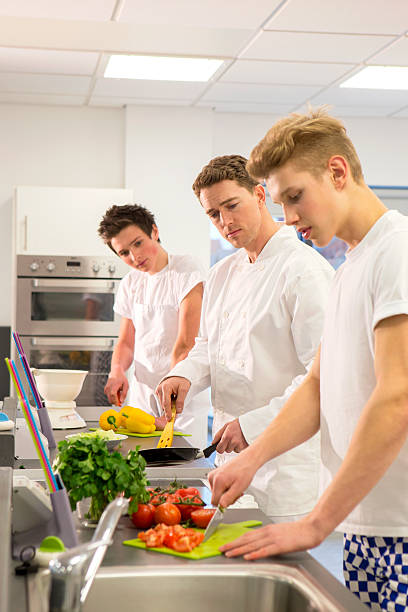 grupo de alunos de aprendizagem de cozinheiros com instrutor - chef trainee cooking teenager imagens e fotografias de stock