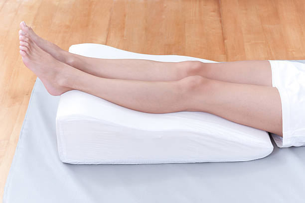 preventing varicose vein A woman's legs lay down on a pillow for relaxing and preventing varicose vein human leg stock pictures, royalty-free photos & images