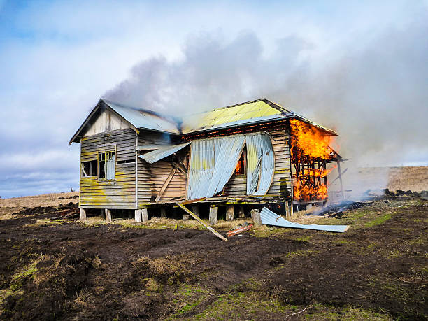 Historic cottage in paddock burning down. stock photo