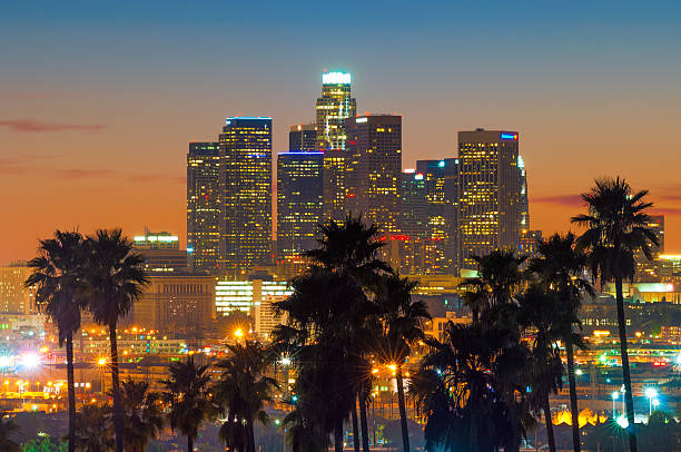 istock Downtown Los Angeles at sunset with palm tree silhouettes 472845262