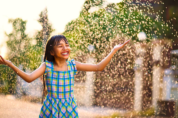 istock A little girl having fun in the rain 472845410
