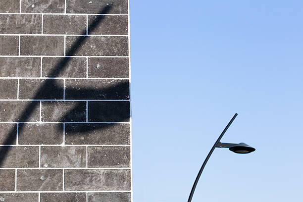 Shadow of a lamppost on the wall with lamppost identical background