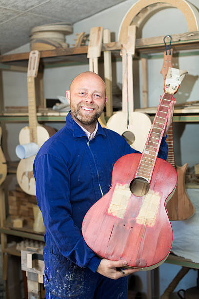 istock Craftsman holding unfinished guitar 472850308