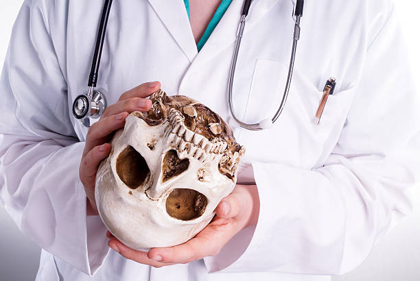 istock Doctor holding a skull in his hands 472850714