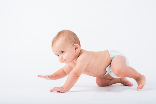 Studio shot of crawling baby boy in diaper