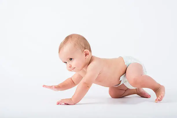 Studio shot of crawling baby boy in diaper