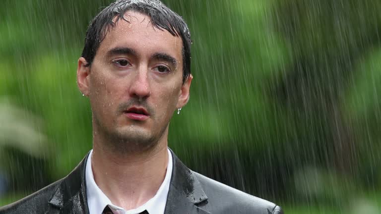 Man wearing suit standing in rain