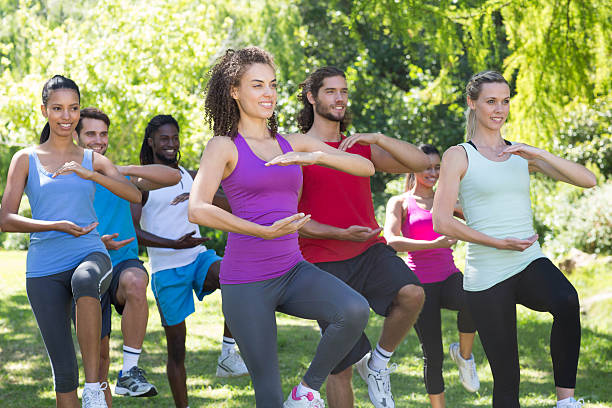 Fitness group doing tai chi in park