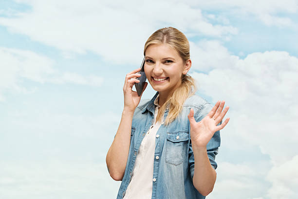 istock Smiling woman on mobile and waving hand 472877168