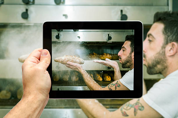 istock Taking picture of baker that blows flour on bread 472879844