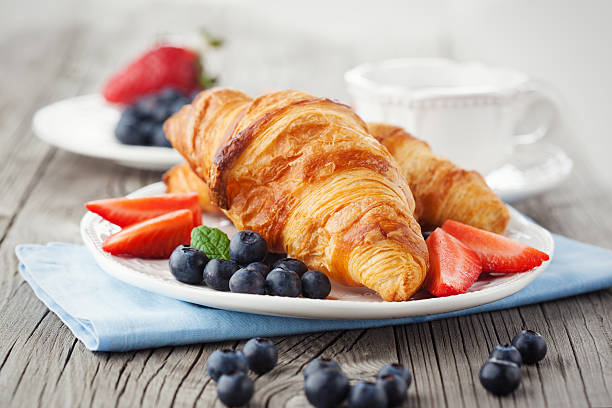 Fresh croissants Delicious breakfast with fresh croissants and ripe berries on old wooden background croissant stock pictures, royalty-free photos & images