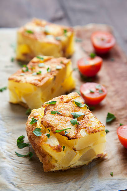 potato frittata with tomatoes and parsley raw stock photo