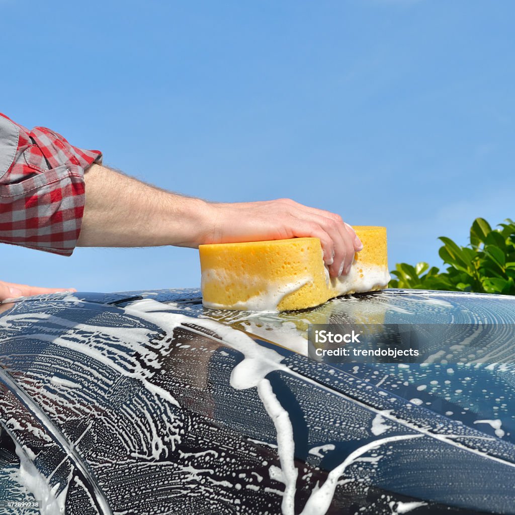 Car Care - Washing a car by hand Man washing a car by hand using a sponge Car Wash Stock Photo
