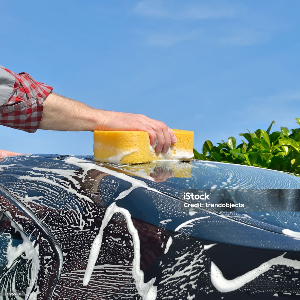 Car Care Man washing a car by hand using a sponge Car Stock Photo
