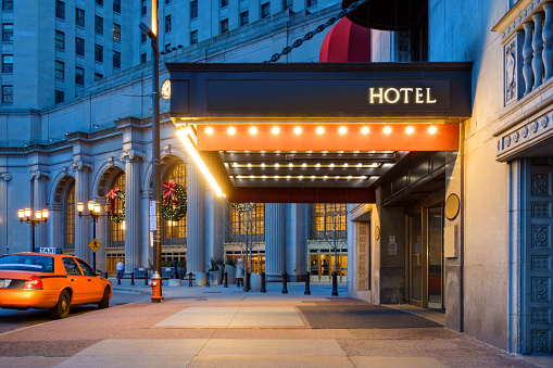 Photo of a hotel entrance and a waiting taxi cab in downtown Cleveland during the winter holidays.