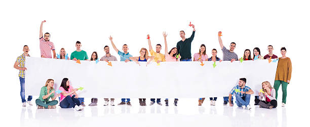 istock Cheerful young people holding a big white placard. 472899606