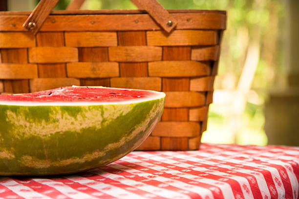 スライスのスイカ屋外でのピクニックテーブルを配しております。夏ます。バスケットます。 - picnic watermelon tablecloth picnic table ストックフォトと画像