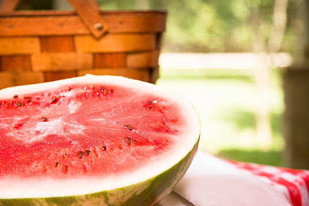 istock Sliced watermelon outdoors on picnic table. Summer. Basket. 472899646