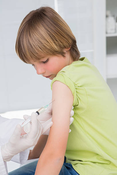 istock Doctor doing injection at little boy 472900160