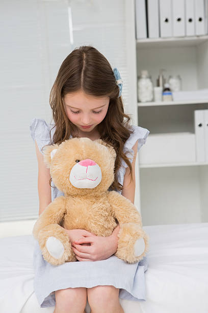 istock Little girl with teddy bear in arms 472902896