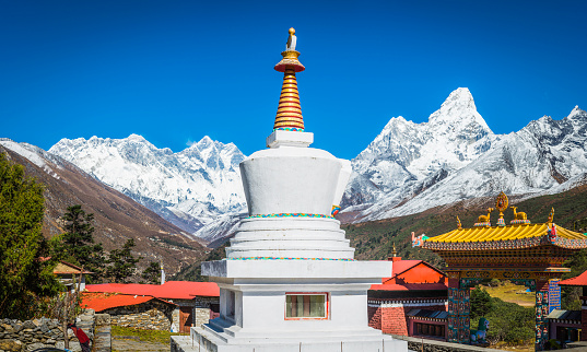 Clear blue high altitude skies over the snow capped peaks of Mt. Everest, Nuptse, Lhotse and Ama Dablam overlooking a traditional white-washed stupa at the historic Tengboche Buddhist monastery in this panoramic Himalayan vista high in the Khumbu, Mt. Everest national Park, Nepal. ProPhoto RGB profile for maximum color fidelity and gamut.