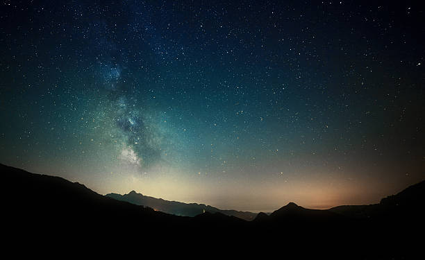 istock night sky stars with milky way on mountain background 472903340