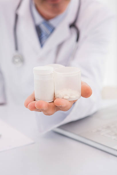 istock Doctor holding pills bottles 472909658