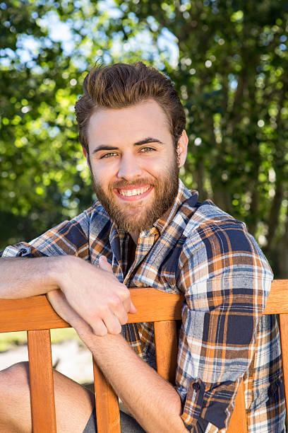 istock Handsome hipster relaxing in the park 472910650
