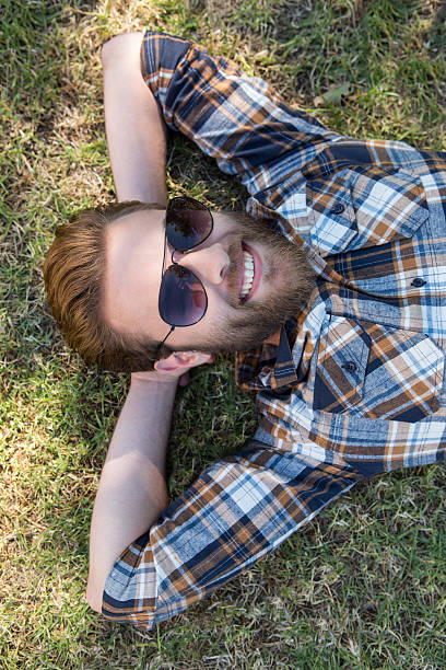 istock Handsome hipster relaxing in the park 472910664