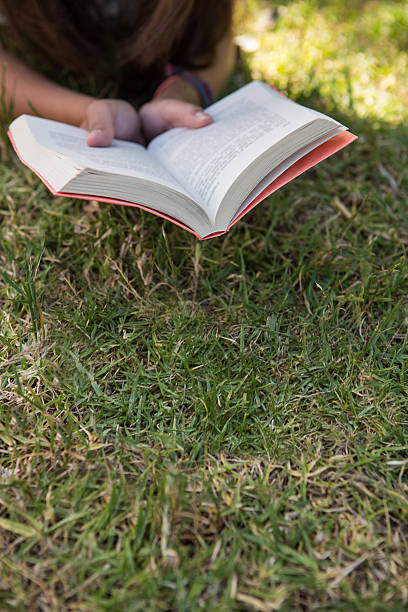 istock Woman reading book in the park 472911632